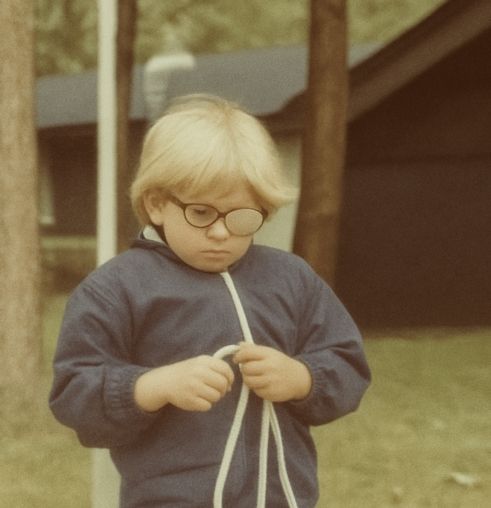 Picture of John R. Miles as a child with a patch on his eyes wearing a blue jacket. John is the founder and CEO of Passion Struck, author of You Matter, Luma and creator of The Matteringverse.